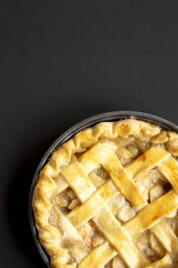 Siyah ahşap arka plan üzerinde ev yapımı elmalı turta, üst görünümü. Düz 