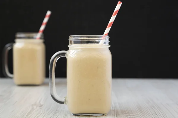 Jordnötssmör banan smoothie i glasburkar, sidovy. Selectiv — Stockfoto