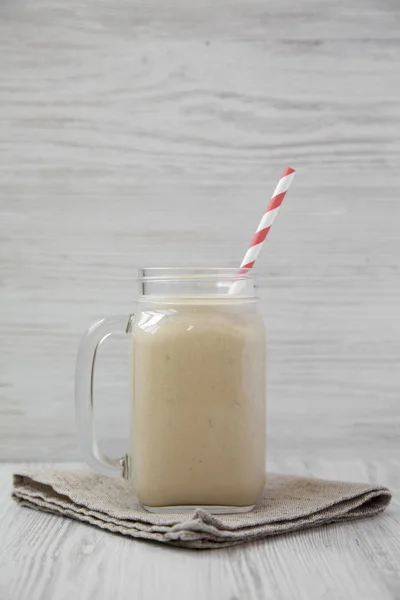Jordnötssmör banan smoothie i en glasburk mugg, sidovy. Clo — Stockfoto