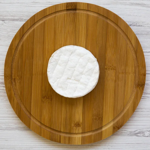 Camembert queso sobre una tabla de bambú sobre un fondo de madera blanca , — Foto de Stock