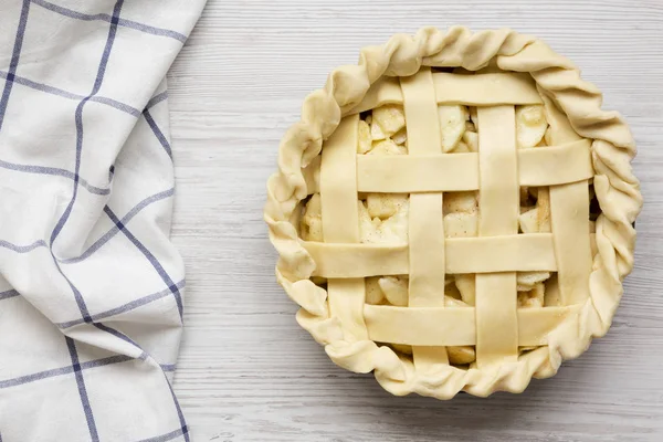 Tarte aux pommes sur une surface en bois blanc, vue de dessus. Pose plate, overhea — Photo