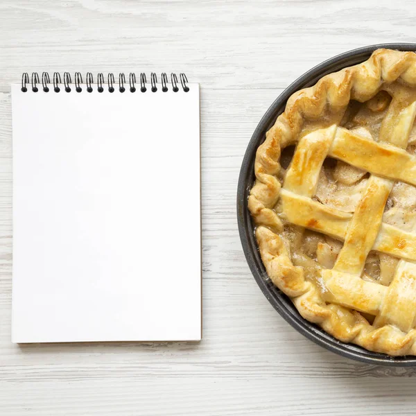 Tarte aux pommes maison, bloc-notes vierge sur fond de bois blanc , — Photo