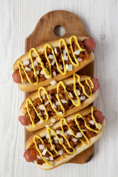 Homemade Coney Island Chili Dog with onion and mustard on a rust