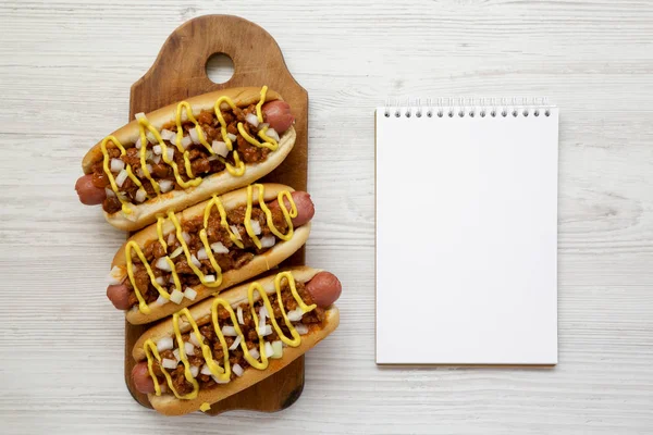 Homemade detroit style chili dog on a rustic wooden board, blank