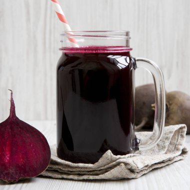 Beyaz ahşap yüzeyüzerinde pancar smoothie Cam kavanoz, yan v