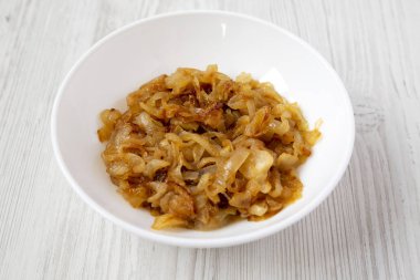 Beyaz bir ahşap s beyaz bir tabak üzerinde ev yapımı karamelize soğan