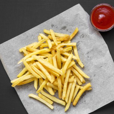 Siyah bir arka plan üzerinde sos ile taze kızarmış lezzetli patates kızartması,