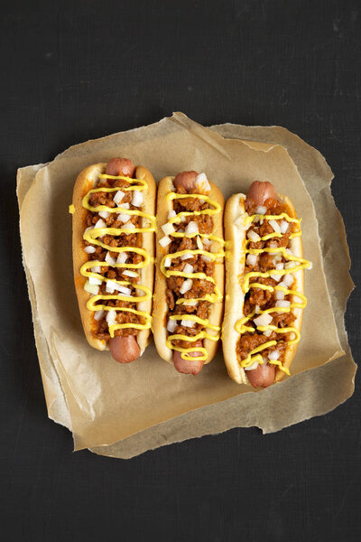 Домашний хот-дог в стиле Детройта на черной поверхности, вид сверху. Ж
