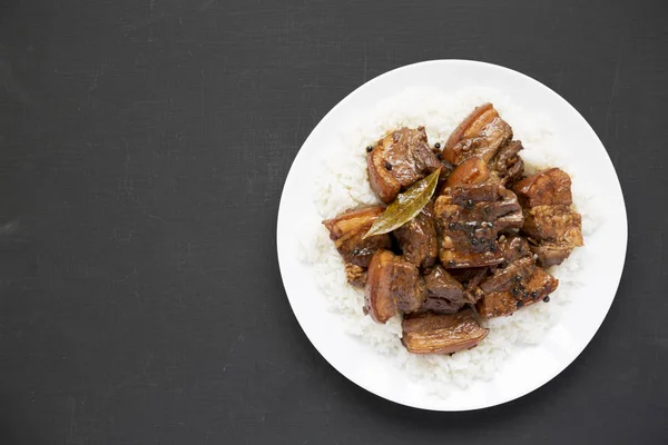 Fatto in casa filippino Adobo maiale con riso su un piatto bianco su bla — Foto Stock