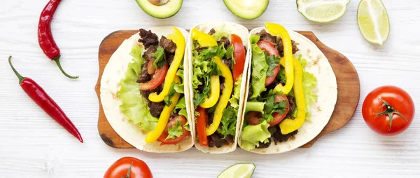 Tortillas with pork, vegetables, avocado, lime on a rustic woode — Stock Photo, Image