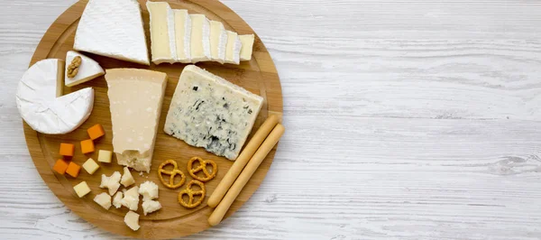 Degustação de queijo com paus de pão, nozes e pretzels em um bamb — Fotografia de Stock