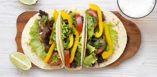 Tacos con carne di maiale, verdure, avocado, lime e birra su un bianco w — Foto Stock