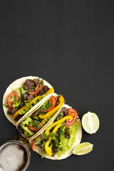 Tortillas de maíz con carne de res y verduras, cerveza y lima en blac —  Fotos de Stock