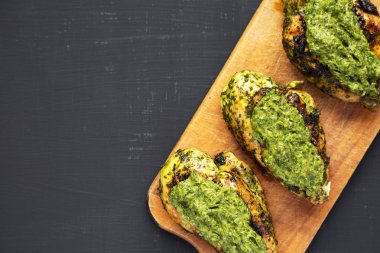 Bir rustik ahşap tahta üzerinde ızgara chimichurri tavuk göğsü