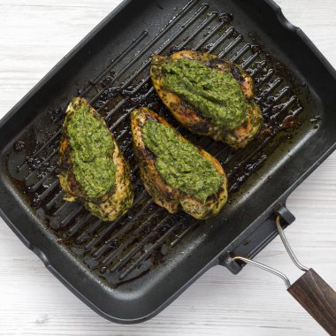 Bir ızgara tavada ev yapımı pişmiş chimichurri tavuk göğsü, ov