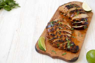 Bir wh üzerinde rustik ahşap tahta üzerinde ızgara chipotle tavuk göğsü