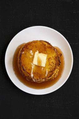 Siyah bir sırt üzerinde beyaz bir tabak üzerinde ev yapımı mısır unu Johnny kek