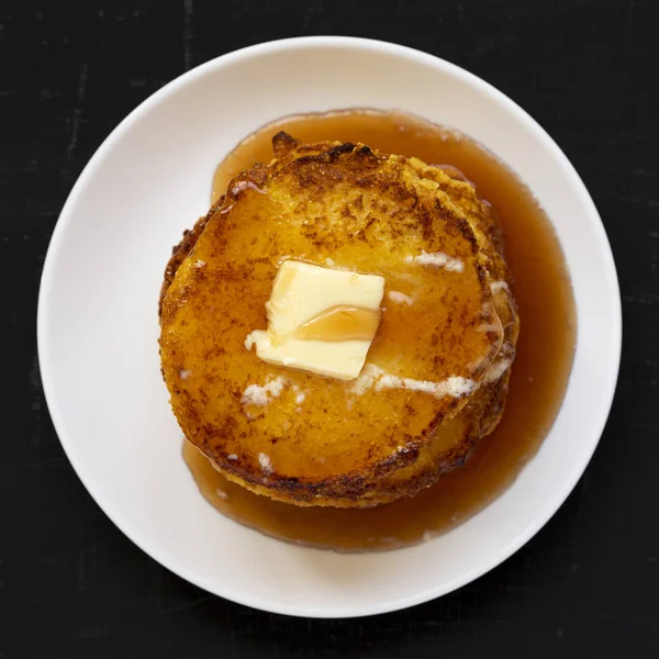 Hausgemachte Maismehl johnny Kuchen auf einem weißen Teller auf einer schwarzen Brandung — Stockfoto