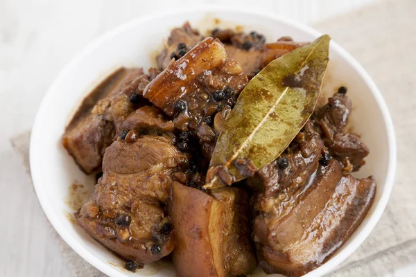 Beyaz ahşap backgro bir kase içinde Ev yapımı Filipinli Adobo Domuz