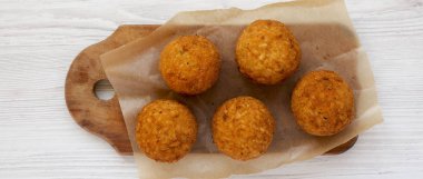 Beyaz ahşap üzerinde rustik ahşap tahta üzerinde ev yapımı kızarmış Arancini