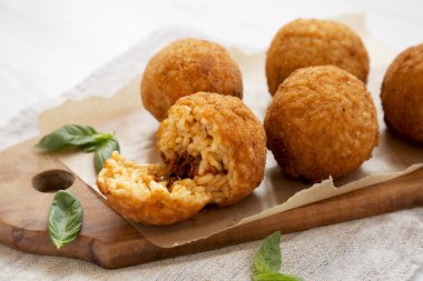 Bir rustik ahşap tahta üzerinde fesleğen ile ev yapımı kızarmış Arancini, sid