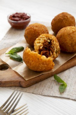 Beyaz bir odunüzerinde fesleğen ve Marinara ile ev yapımı kızarmış Arancini