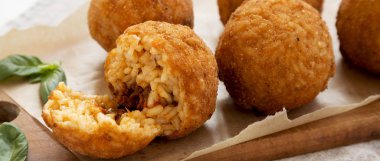 Bir rustik ahşap tahta üzerinde fesleğen ile ev yapımı kızarmış Arancini, sid