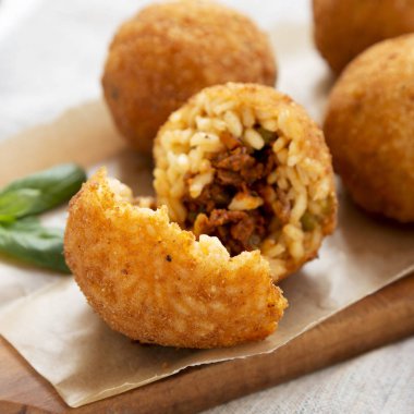 Rustik ahşap tahtaüzerinde ev yapımı kızarmış Arancini, yan görünüm. Ita