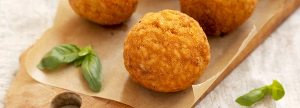 Homemade fried Arancini with basil on a rustic wooden board, low — Stock Photo, Image