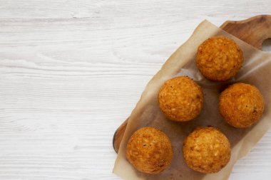 Beyaz ahşap üzerinde rustik ahşap tahta üzerinde ev yapımı kızarmış Arancini