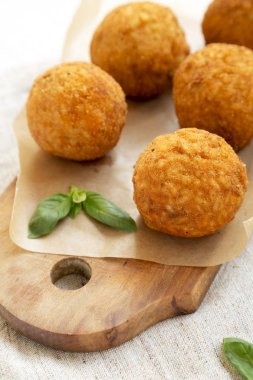 Bir rustik ahşap tahta üzerinde fesleğen ile ev yapımı kızarmış Arancini, sid