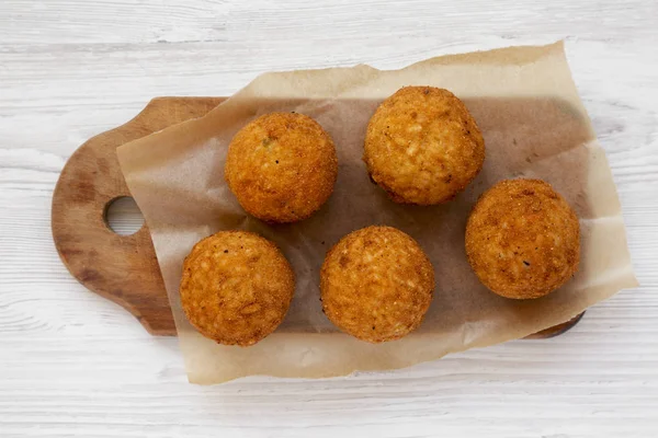 Arancini frito casero en un tablero rústico de madera en una madera blanca — Foto de Stock