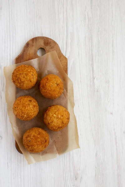 Arancini frito casero en un tablero rústico de madera en una madera blanca — Foto de Stock