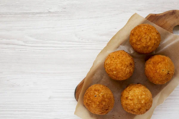 Beyaz ahşap üzerinde rustik ahşap tahta üzerinde ev yapımı kızarmış Arancini