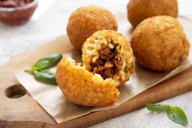 Beyaz bir odunüzerinde fesleğen ve Marinara ile ev yapımı kızarmış Arancini