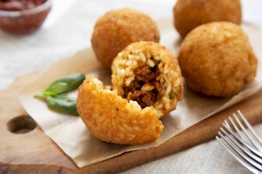 Beyaz bir odunüzerinde fesleğen ve Marinara ile ev yapımı kızarmış Arancini