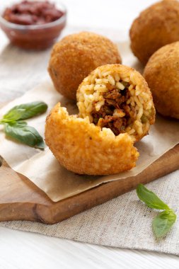 Beyaz bir odunüzerinde fesleğen ve Marinara ile ev yapımı kızarmış Arancini