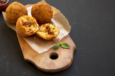 Siyah bir sırt üzerinde fesleğen ve Marinara ile Ev yapımı kızarmış Arancini