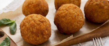 Bir rustik ahşap tahta üzerinde fesleğen ile ev yapımı kızarmış Arancini, düşük