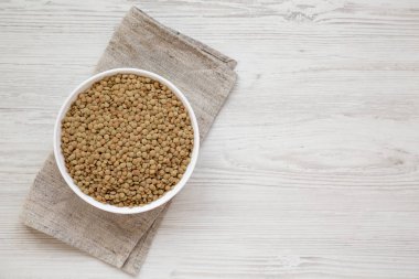 Beyaz ahşap backgrou beyaz bir kapta Organik yeşil mercimek