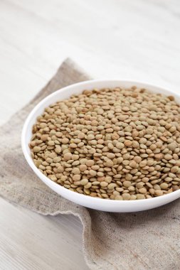 Beyaz ahşap backgrou beyaz bir kapta Organik yeşil mercimek