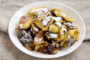 Beyaz tabakta ev yapımı Alman Kaiserschmarrn gözleme, yan vi