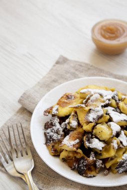 Beyaz tabakta ev yapımı Alman Kaiserschmarrn gözleme, yan vi