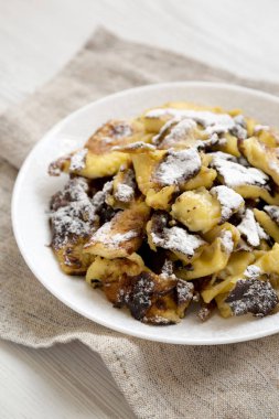 Beyaz tabakta ev yapımı Alman Kaiserschmarrn gözleme, yan vi
