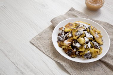Beyaz tabakta ev yapımı Alman Kaiserschmarrn gözleme, yan vi