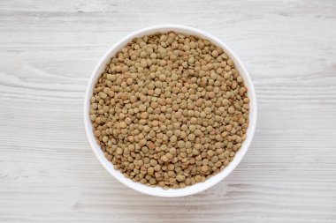 Beyaz ahşap backgrou beyaz bir kapta Organik yeşil mercimek