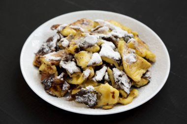 Bir bla üzerinde beyaz bir tabak üzerinde ev yapımı Alman Kaiserschmarrn gözleme