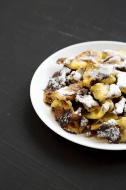 Bir bla üzerinde beyaz bir tabak üzerinde ev yapımı Alman Kaiserschmarrn gözleme
