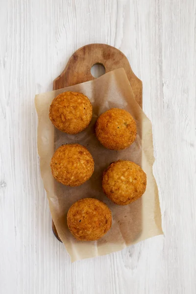 Beyaz ahşap üzerinde rustik ahşap tahta üzerinde ev yapımı kızarmış Arancini