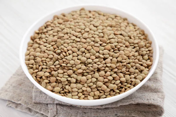 Beyaz ahşap backgrou beyaz bir kapta Organik yeşil mercimek